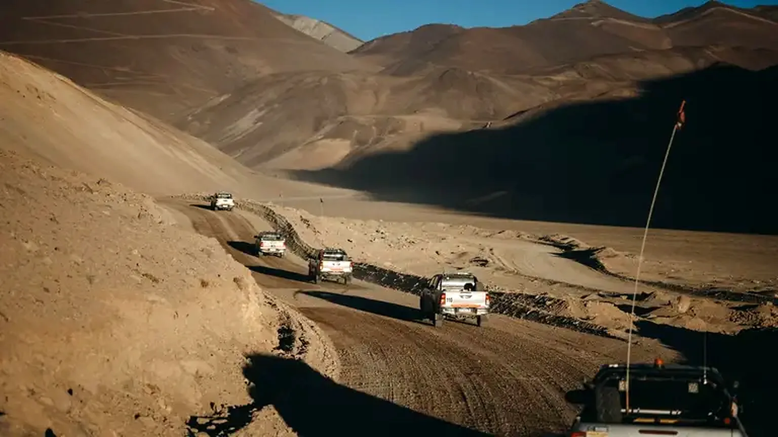Flota de camionetas de TCV circulando por un camino minero en la cordillera de San Juan